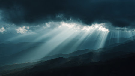 Stormy sky with rays of light shining through dark clouds in the mountainsの写真素材