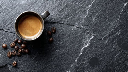 Coffee cup and coffee beans on black stone background, top viewの写真素材