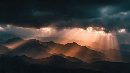 Dramatic sunset in the mountains. The rays of the sun make their way through the clouds.の写真素材