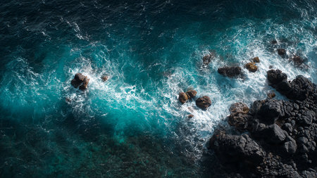 Aerial view of ocean waves crashing on the rocks. Turquoise water.