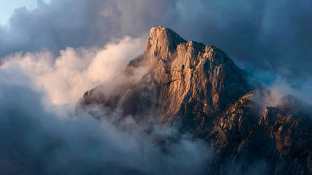 Mist gently softens the line between waterfall and canopy in a radiant blend of cool and warm tones.の写真素材