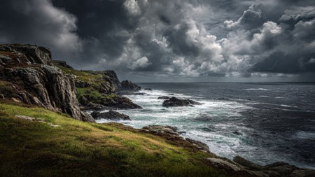 Mossy stones form the earthy base while the waterfall slices vertically upward with bright highlights.の写真素材