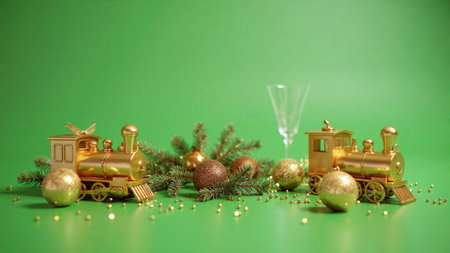 Christmas decoration with golden train and glass of champagne on a green background