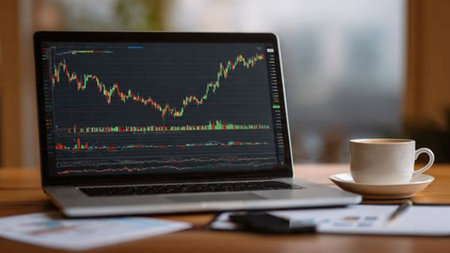 A workspace designed for financial analysis featuring laptop charts and warm morning coffee.の写真素材