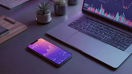 A wooden workspace holding a laptop showing trend lines next to fresh morning coffee.の写真素材
