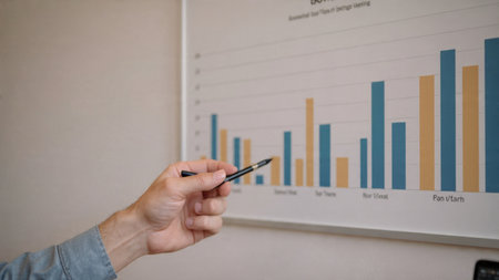 A laptop displaying market heat maps rests beside a cup of latte and printed research.の写真素材
