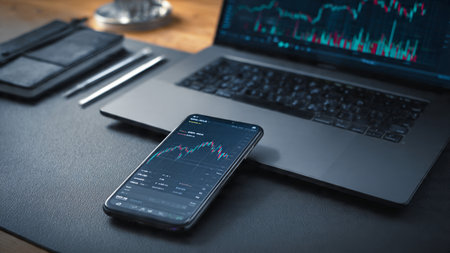 A wooden desk with a laptop showing financial analytics, reports, and a warm beverage.の写真素材