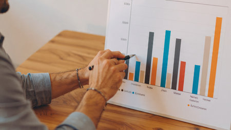 A trading dashboard loaded with market figures sits beside documents and coffee.の写真素材