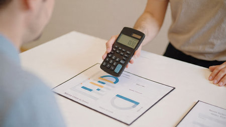 A workspace enriched with market data on laptop, papers, and a freshly brewed beverage.の写真素材