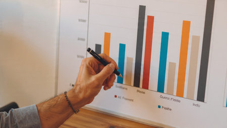 A contemporary wooden desk featuring laptop data screens and a warm ceramic coffee.の写真素材