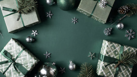 A textured green background paired with rustic wrapped presents and aged silver decorative pieces.の写真素材