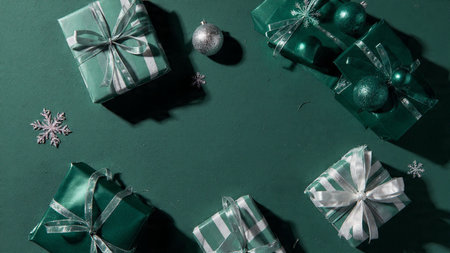A festive layout with matte gift boxes in green and silver tones.の写真素材