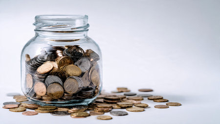 Simple budgeting composition with a jar tipped and coins flowing outward in a smooth arc,...