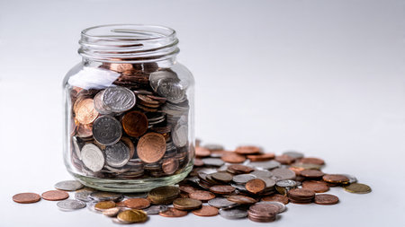 Clean modern budgeting display with an empty jar and carefully aligned coins under soft lighting.