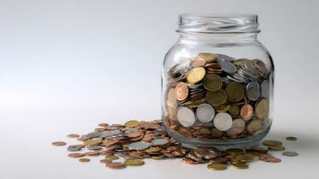 High-key wealth display with a tipped jar and coins scattered in a controlled manner.