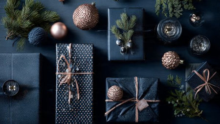 A sophisticated composition of premium wrapped gifts in midnight blue and rose-gold tones, styled with cinematic lighting.の写真素材