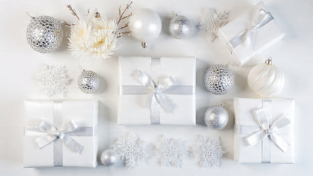 White christmas gifts with silver balls and snowflakes on white background