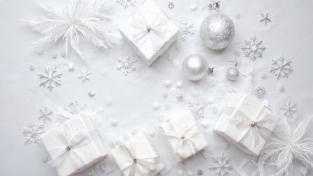Christmas background. White gift boxes, white snowflakes and christmas balls on white background. Flat lay, top viewの写真素材