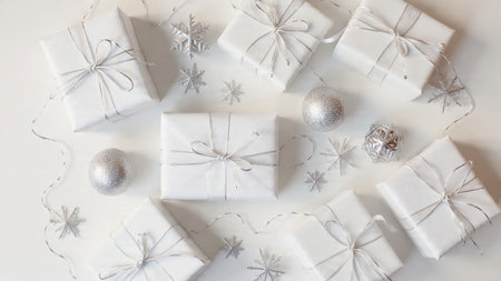 Christmas and New Year holiday background. White gift boxes, silver balls, snowflakes on white...