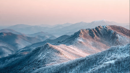A dreamy pastel sunrise hovers above ultra-detailed winter mountains.の写真素材
