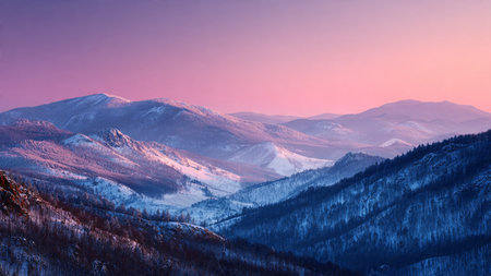 Snow caps glisten beneath a pastel sunrise sky.の写真素材