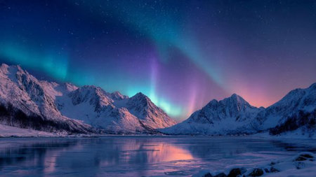 Snowy peaks glowing beneath radiant northern lights at night.