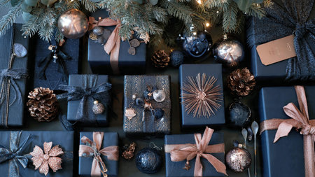Christmas and New Year background with black gift boxes and fir tree branchesの写真素材