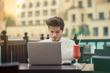 Arab young businessman working with laptop in cafeの写真素材