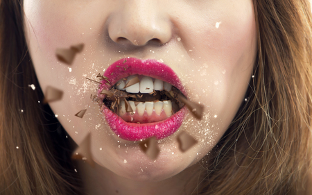 young woman crashing chocolate with her teethの写真素材