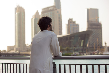 Thoughtful guy standing on the bridge looking into the distance, looking at city , considering new opportunity, thinking over future.の写真素材