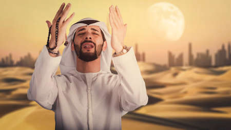 Arabic man hand holding a muslim rosary in the desert.