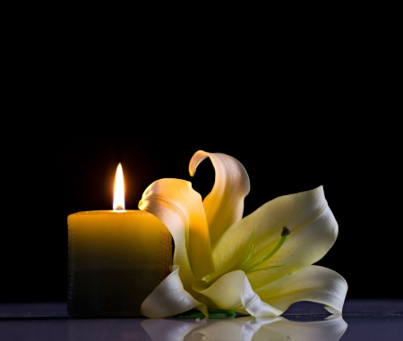 still-life with candle and lilly on black backgroundの写真素材