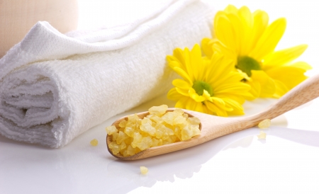 spa still, white towel, salts in wooden spoon and yellow flowers on white の写真素材