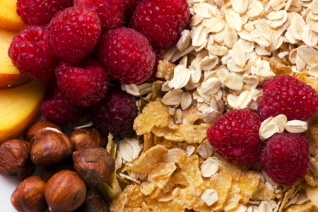 Mixed of beautiful colorful fresh fruits, raspberry, nats, and flakes, macro