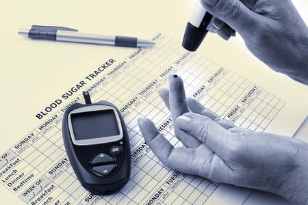 diabetic concept -  elderly woman's hands, glucometer, medicine form and pen in black and white color on white background の写真素材