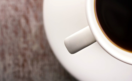 close-up cup  with brown drink and saucer on blurred background with place for your textの写真素材