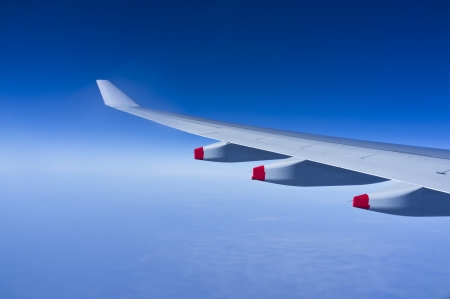 Airplane wing over blue skies and cloudsの写真素材