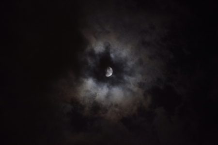 A bright moon with clouds in the night sky