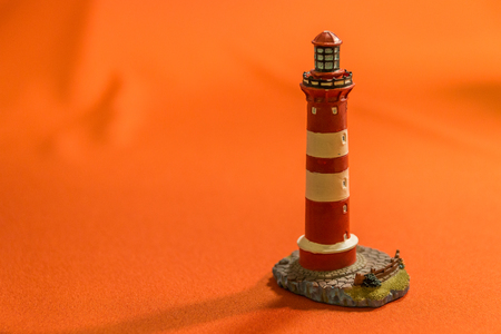 red backdrop isolating a retro old lighthouseの写真素材