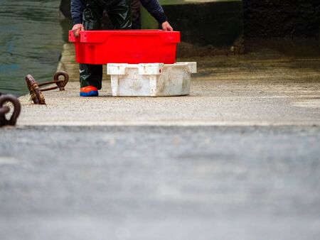 Fisherman unloading boxes of fish in a port of a village in the Basque country.の写真素材