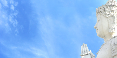 Side face of Buddha and heaven blue sky. The Side face of Avalokitesvara (Awalokitesuan) statue at...