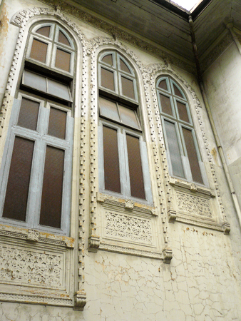 Old wooden Neo-Classic windows and cracked of old cement wall, the vintage windows of antique abandoned house.の写真素材