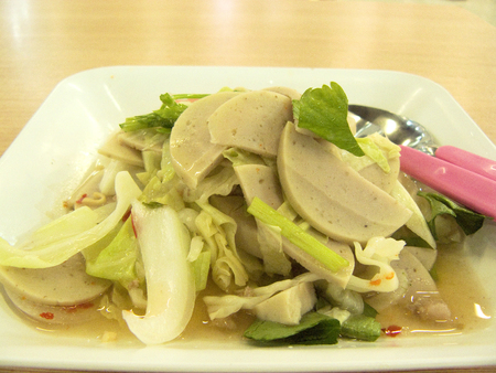 Delicious Asia - Asian eating Thai food. Spicy Vietnamese Sausage Salad, Close up front view in a white plate on wooden table background.の写真素材