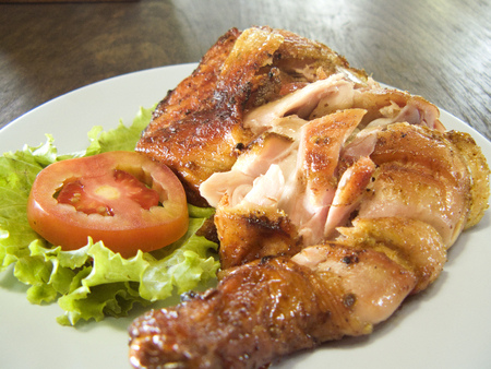 Delicious Asia - Asian eating: Thai traditional food. Marinated grilled chicken cooked on a plate. Close up on wooden table backgroundの写真素材