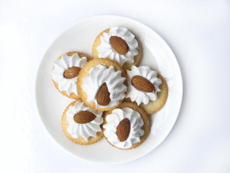 A photo of Baking pastry, Almond Meringue biscuits. Close up top view of dessert on a white plate isolated on white background.の写真素材