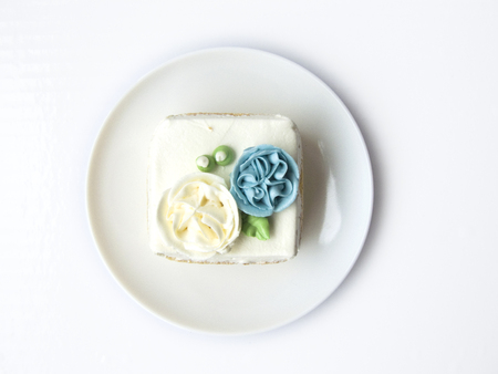 Close up top view of Chiffon snow flower cake. The chiffon vanilla cake decorated with cream of flower blue and white on the top of cake. Putting on white plate, Isolated on white background.の写真素材