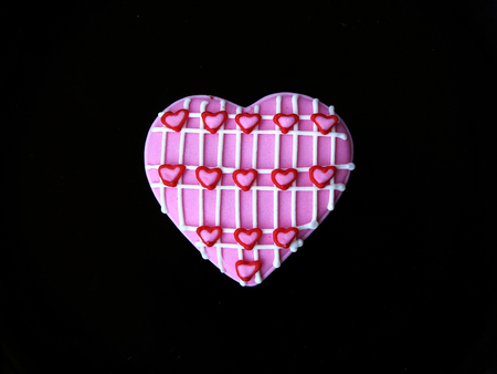 Chocolate lover cookie. Chocolate cookies in sweet heart shape decorated with colorful sugar close up a top view isolated on black background.の写真素材