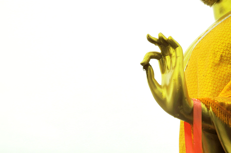 The hand of gold statue of Buddha and water drop isolated on white background. A sign of buddha hand is a blessing for peace to coming to all of human in the world.の写真素材