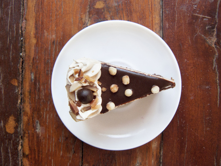 Delicious Chocolate, Mocha almond cake, The layer coffee and chocolate cake decorated with almond  and on a white plate. Close up top view on wooden table background.の写真素材