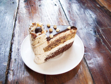 Delicious Chocolate, Mocha almond cake, The layer coffee and chocolate cake decorated with almond  and on a white plate. Close up side view on wooden table background.の写真素材